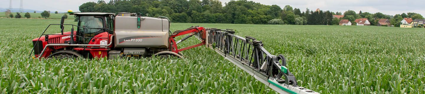 Maisfeld mit Pflanzenschutzspritze