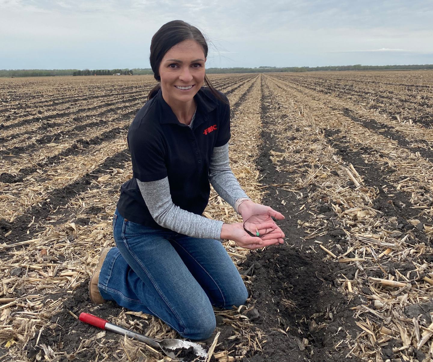 Female in farm field inspecting crop
